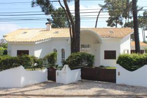 克洛伊奥斯Villa near Beach & Lisbon的前面有栅栏的白色房子