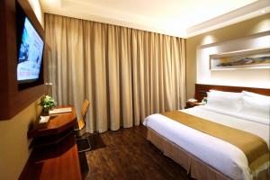 上海麦新格精品酒店川沙店的配有一张床和一台平面电视的酒店客房