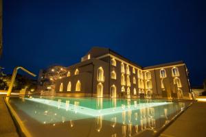 卡塔尼亚白鹭城大酒店 的一座晚上设有游泳池的建筑