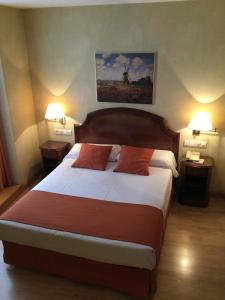 布尔戈斯科登酒店的一间卧室配有一张大床和两盏灯