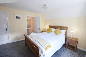 纽卡斯尔Hillyard Mews的卧室配有一张带黄色枕头的大型白色床。