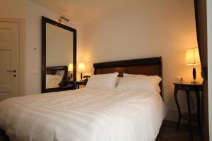 庞特内阿尔比拉坎达阿拉斯塔兹翁酒店的卧室配有一张大白床和大镜子