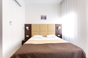 圣彼得堡格罗霍瓦亚塔利斯曼酒店的一间卧室配有一张大床和两个枕头