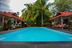拉迈满月苏梅之家酒店的一座大蓝色游泳池,位于房子前