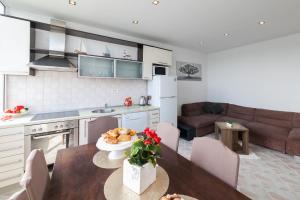 扎达尔Apartman Bordura的厨房以及带桌子和沙发的客厅。