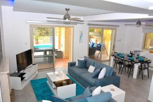 佩亚Villa Ocean Breeze的客厅配有蓝色的沙发和电视
