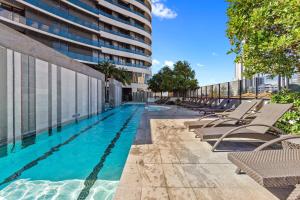 黄金海岸Oracle - 5 Star Luxury - Level 25的一座带躺椅的游泳池和一座建筑