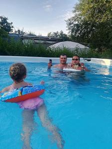 克里尚Camping Casuta Mihaela的两个男人和一个孩子在游泳池里