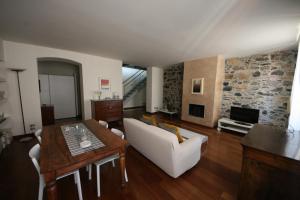 斯培西亚La Pietra del Golfo的带沙发、桌子和电视的客厅