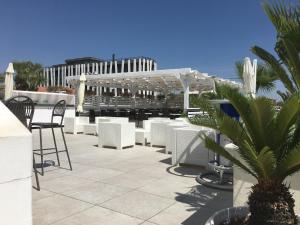 卡斯特拉巴特滨海Casa Villaggio的庭院配有白色的桌椅和凉亭。