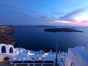 易莫洛林Katikies Chromata Santorini - The Leading Hotels of the World的夜晚的海景与白色建筑