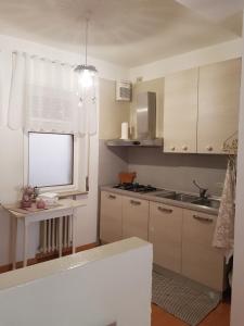 贝卢诺Appartamenti Mori的厨房配有白色橱柜、水槽和窗户。