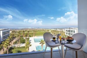 布兹尼盖The View Bouznika的阳台配有桌椅,享有游泳池的景致。