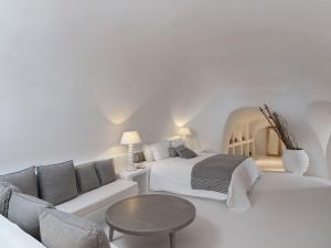 易莫洛林Katikies Chromata Santorini - The Leading Hotels of the World的白色卧室配有床和沙发
