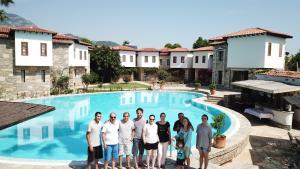 达利安Osmanli Hani Apart Hotel的一群人站在游泳池前
