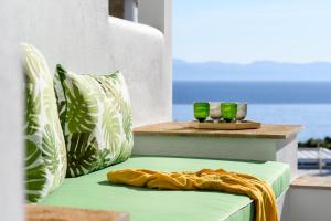 帕利乌里翁Villa D'Oro - Luxury Villas & Suites的绿色椅子和2个绿色和白色枕头