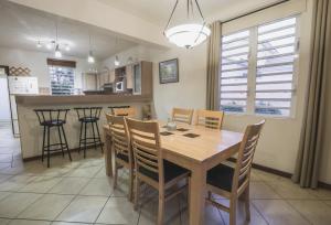 塔马兰Villa Bayswater的厨房以及带木桌和椅子的用餐室。