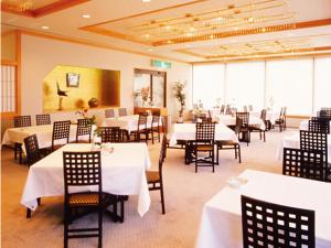 琴平町琴平町河畔酒店的一间设有白色桌椅的用餐室