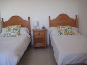 桑卢卡尔-德巴拉梅达Casa Algaida的一间卧室设有两张床和床头柜