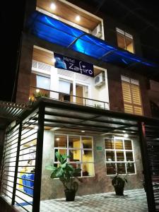 莱蒂西亚Hotel Zafiro的上面有蓝色的灯光的建筑