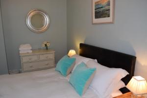 阿伯里斯特威斯Awel Mor 3 Luxury Apartment的一间卧室配有一张带蓝色和白色枕头的床