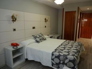 卡塞雷斯洛斯那然约斯酒店的一间卧室配有一张带黑白毯子的床