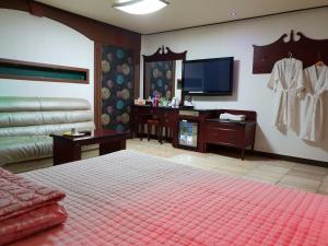 釜山普拉斯汽车旅馆的一间卧室配有一张床和一台平面电视