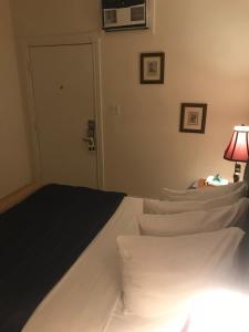 基韦斯特New Orleans House - Gay Male Adult Guesthouse的一间卧室配有带白色枕头和灯的床