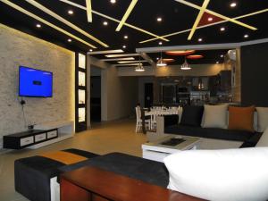 艾因苏赫纳Three-Bedroom Apartment at Louly Beach Resort的客厅配有沙发和墙上的电视