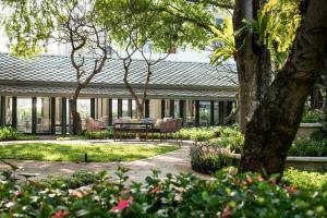 曼谷曼谷拉威坎拉亚酒店的花园配有桌椅和树木