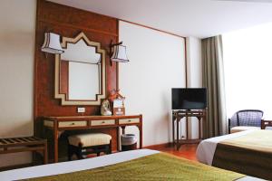 清迈Chiang Mai Orchid Hotel SHA EXTRA PLUS的酒店客房配有镜子和书桌