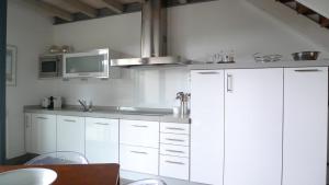 利亚内斯克尤别墅公寓式酒店的厨房配有白色橱柜和微波炉