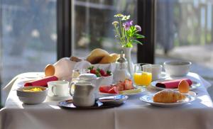 博尔扎诺巴德圣伊西多尔酒店的一张带早餐食品和饮料的白色桌子