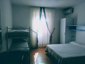 ChiessiB&B da AnnaMaria的一间卧室设有两张双层床和一扇窗户。