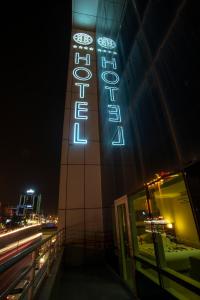 苏莱曼尼亚Hotel Halwachy的一座晚上有 ⁇ 虹灯标志的建筑