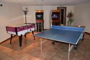 坎皮泰洛迪法萨费德拉公园酒店的两个乒乓球桌,位于带街机的房间