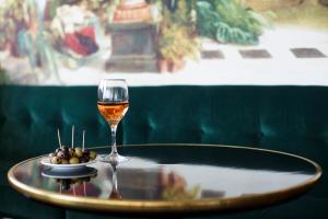 戛纳Hôtel Cannes Centre Univers的一杯葡萄酒和一碗橄榄油在桌上