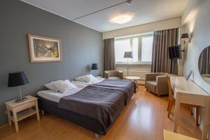 库奥皮奥萨沃尼亚经济酒店的酒店客房设有一张大床和一张书桌。