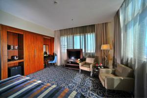阿布扎比阿布扎比滨海路华美达酒店的酒店客房设有床和客厅。