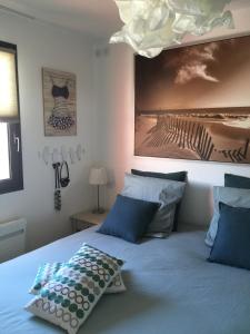 艾特雷detente rochelaise的一张带蓝色枕头的床和一张墙上的照片
