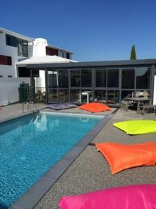 艾特雷detente rochelaise的一座游泳池,在一座建筑前设有色彩缤纷的枕头