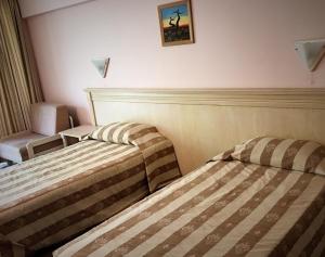 卡瓦尔纳Hotel & SPA Otdih的酒店客房,配有两张床和椅子