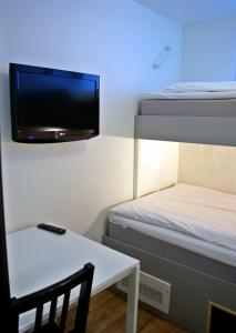 乌普萨拉中央车站酒店的小房间设有一张床和墙上的电视