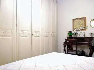 索伦托Casamia Sorrento BB的卧室配有白色衣柜、书桌和床。