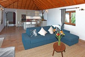 蒂哈拉费Villa Vista Mar的一间带蓝色沙发的客厅和一间厨房