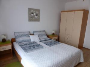 扎达尔Apartments Toni, Borik的卧室配有白色的床和橱柜。