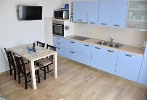 诺维格勒伊斯特拉Apartmani Diana的厨房配有蓝色橱柜和桌椅