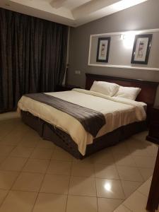 巴哈Almeswari Suites的一间卧室,卧室内配有一张大床
