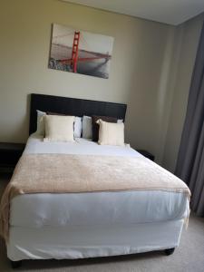 巴利托Zimbali Suite 523的卧室配有一张白色大床,墙上挂着一幅画