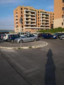 菲乌米奇诺Perugino Apartments的站在停车场前的人的影子